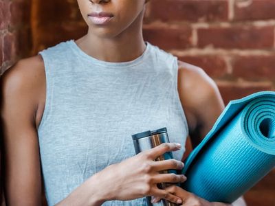 A detailed shot of a yoga block and a water bottle next to a mat.