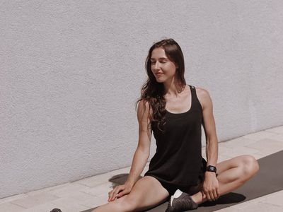 Woman performing a deep, controlled stretching pose on a yoga mat.